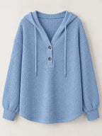 Light blue waffle-knit button hoodie with hood, gold buttons, and drawstring ties.