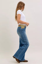 Women’s mid-rise straight jeans, blue denim with tan corduroy waistband, side step view