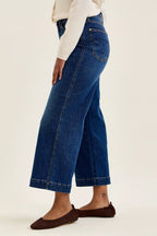 Dark indigo wide-leg ankle jeans, side view with belt loops and seam stitching