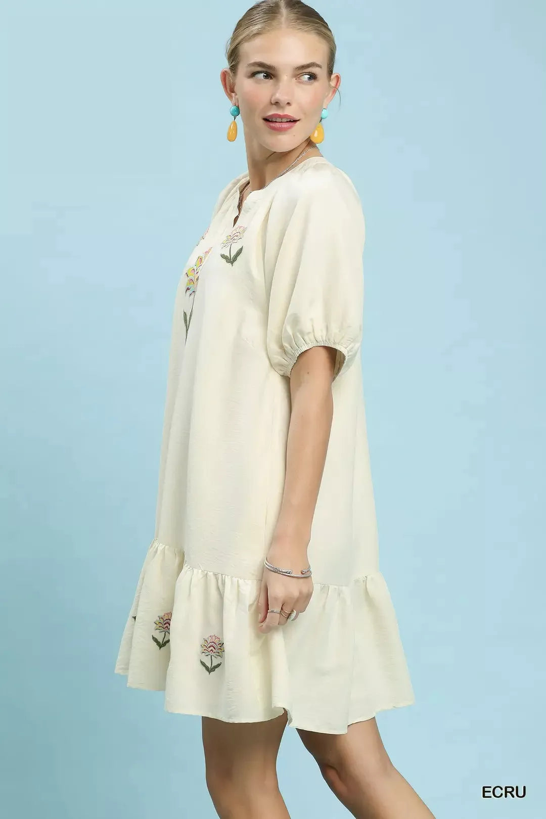Ecru babydoll dress with floral embroidery at hem and bodice, puff sleeves, V-neck