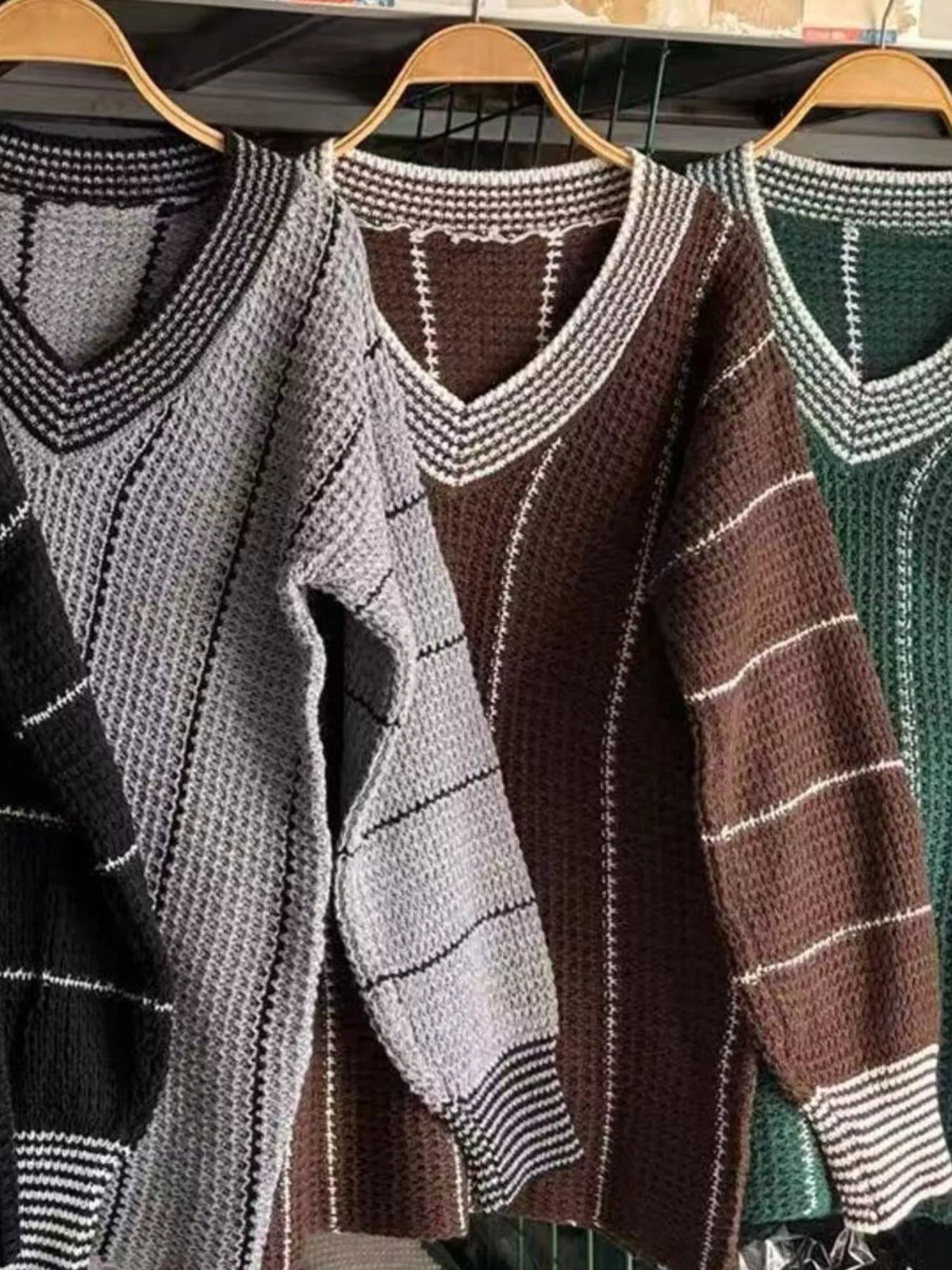 Striped V-neck textured knit sweaters on hangers with ribbed cuffs and cuffs trim