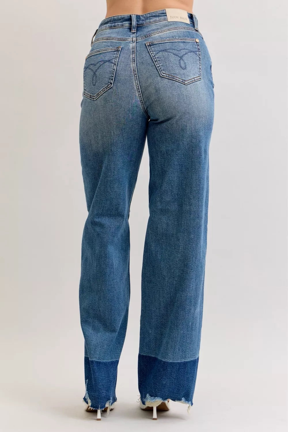 High-waist straight jeans in medium blue denim, back view with raw hem