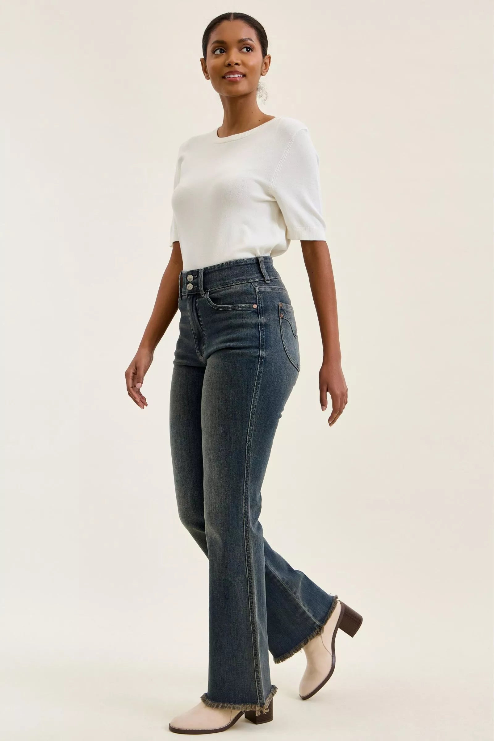 High-waist straight dark blue jeans in side view with frayed hem and belt loops