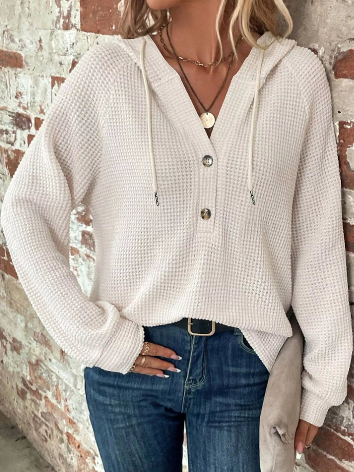 White waffle-knit button hoodie with hood and drawstring ties; long sleeves and buttons.