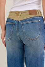 Women’s blue jeans with tan corduroy waistband, button closure and front patch pockets