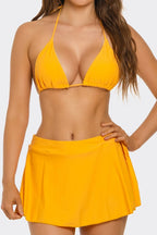 Yellow triangle bikini top and high-rise swim skirt close-up, halter straps