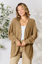 Tan/brown ribbed cocoon cardigan with open front and long sleeves, worn over a white tank.
