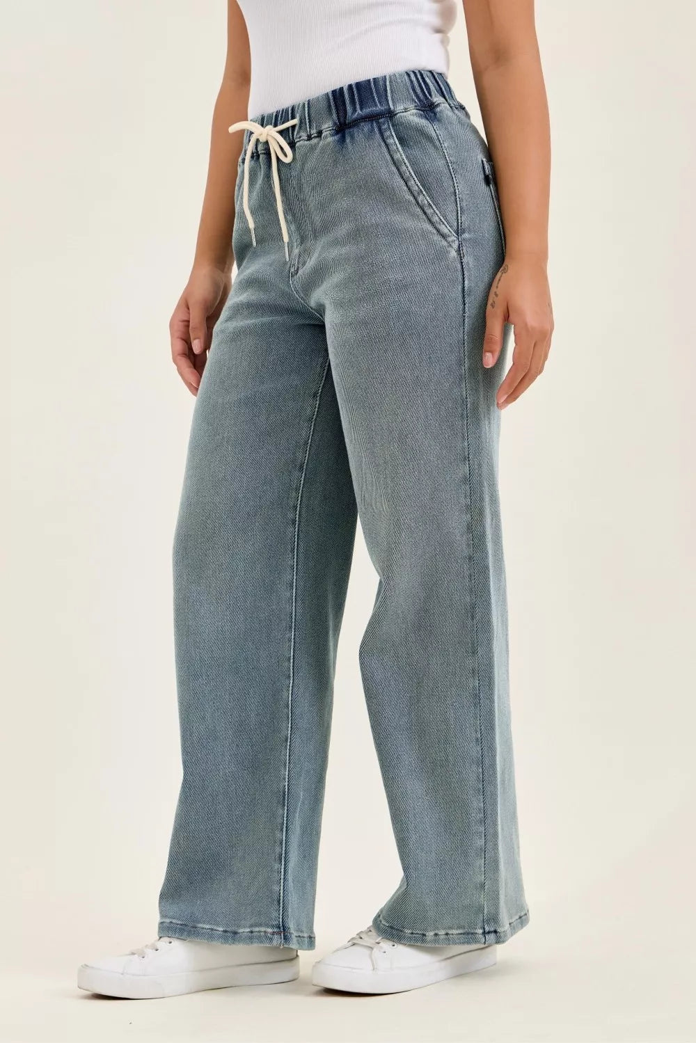 Medium-wash baggy jeans, back view with elastic waistband and relaxed straight fit