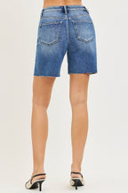 Medium-wash high-rise denim shorts with raw hem, back patch pockets, belt loops.