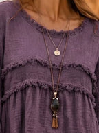 Purple frayed-trim peplum blouse neckline with scalloped ruffle trim and tiered bodice