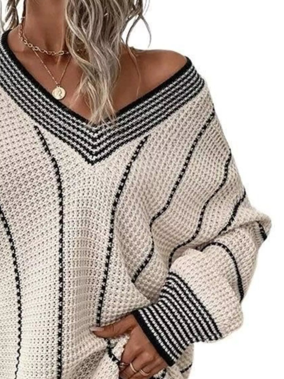 Cream textured knit V-neck sweater with black contrast striped trim and long sleeves.