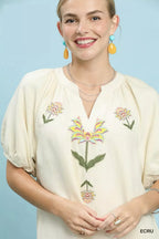 Ecru embroidered babydoll dress close-up, V-neck and floral chest embroidery