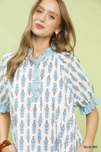 Light blue floral-print tiered mini dress close-up: button front and ruffled collar