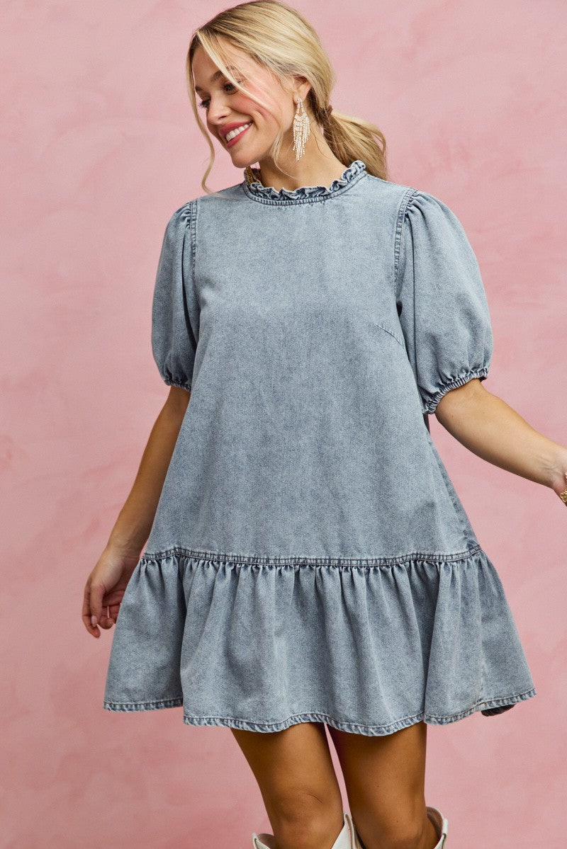 Light-wash denim mini dress with ruffled neckline and puff sleeves, tiered hem