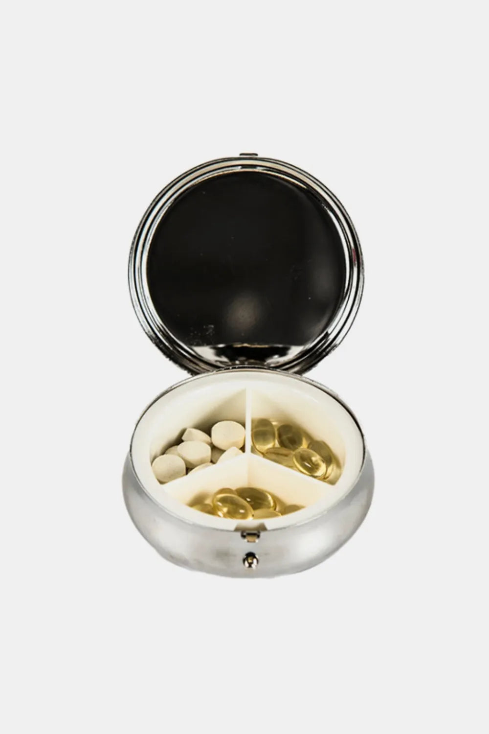 Silver round 3-compartment pill case open, showing white and gold pills