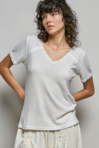 Off-white textured knit top with lace-trim V-neck and short puff sleeves