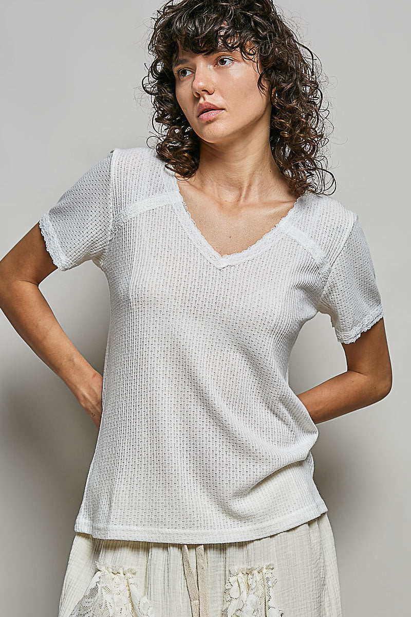 Off-white textured knit top with lace-trim V-neck and short puff sleeves