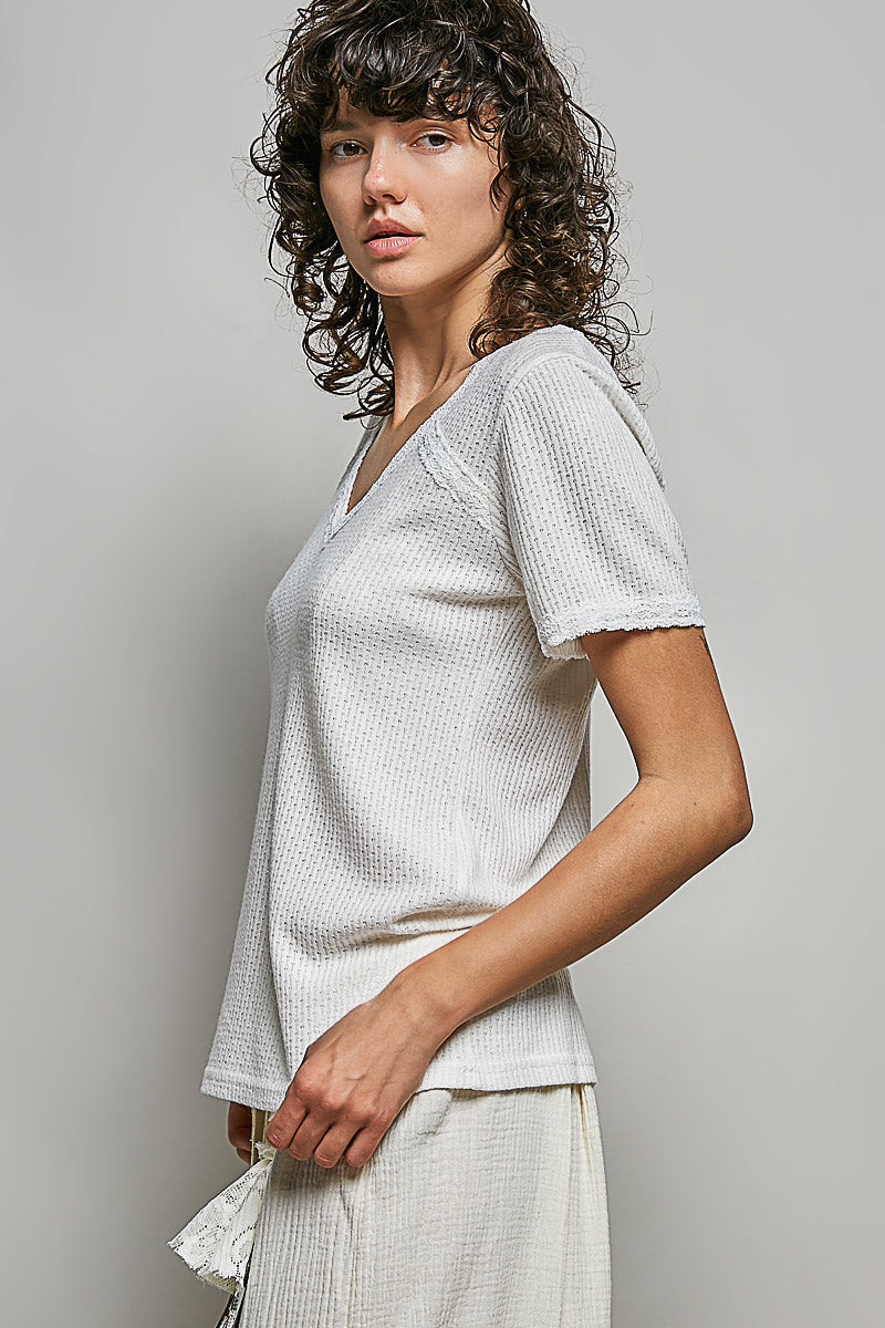 Off-white textured knit top with V-neck and short sleeves, side view