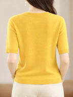 Yellow round-neck short-sleeve sweater shown from the back with ribbed hem