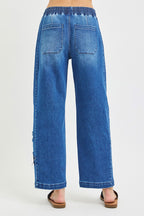 Back view of medium-wash cropped barrel jeans with elastic waistband and relaxed leg shape