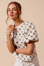 Ivory textured woven top with black bow pattern and puff bubble sleeves