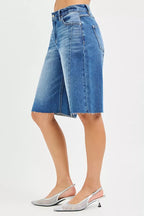 Side view of medium-wash raw-hem denim jorts with contrast seam detailing