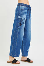 Side view of medium-wash cropped barrel jeans with drawstring waist and star patch details