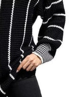 Black textured knit sweater sleeve with white striped ribbed cuff detail