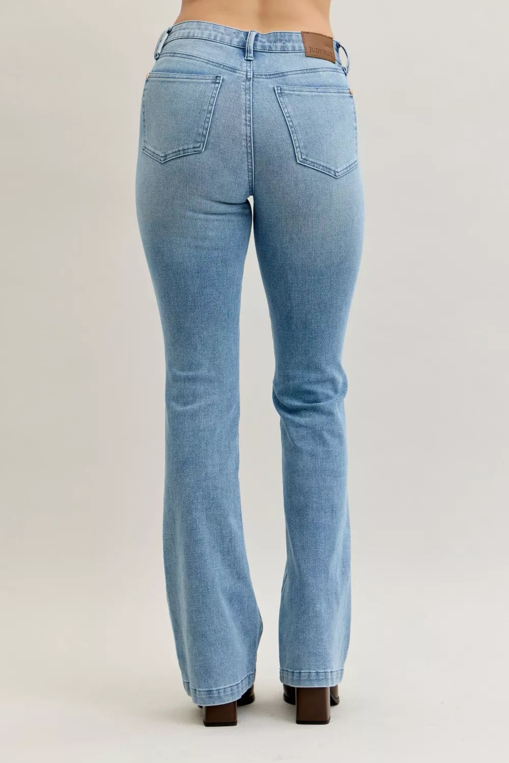 Light blue mid-rise bootcut jeans with back center seam and rear patch pockets