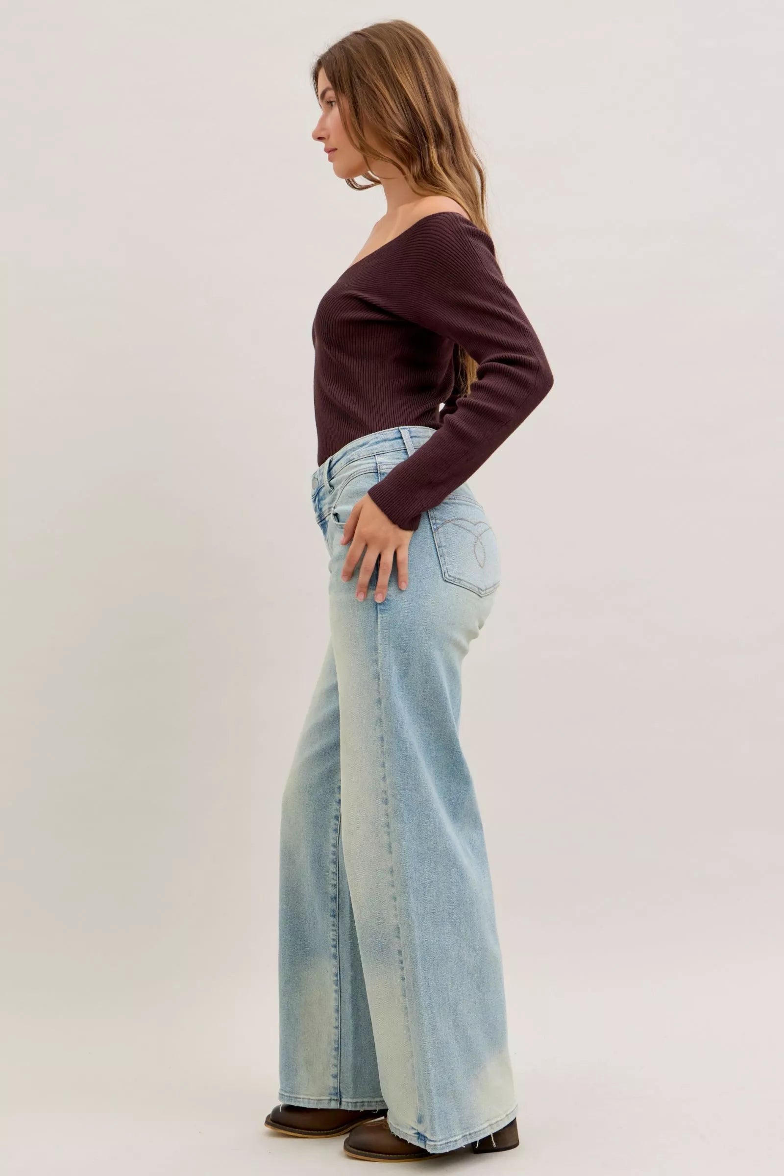 Light blue high-waist straight jeans angled side view with front pockets and wide legs
