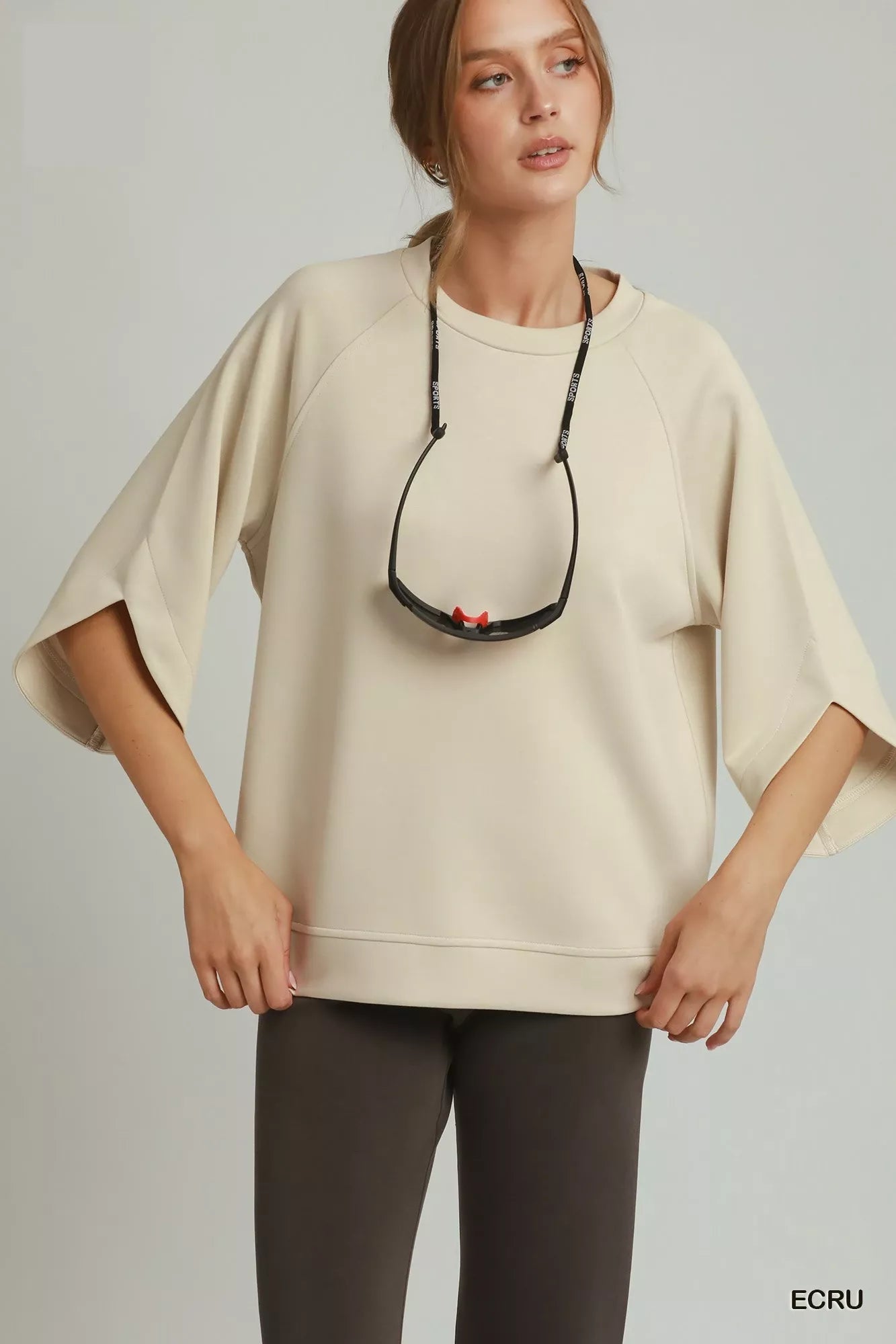 Ecru raglan sleeve round-hem top with crew neckline and relaxed pullover fit