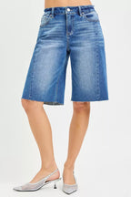 Medium-wash raw-hem denim jorts with five-pocket styling and belt loops