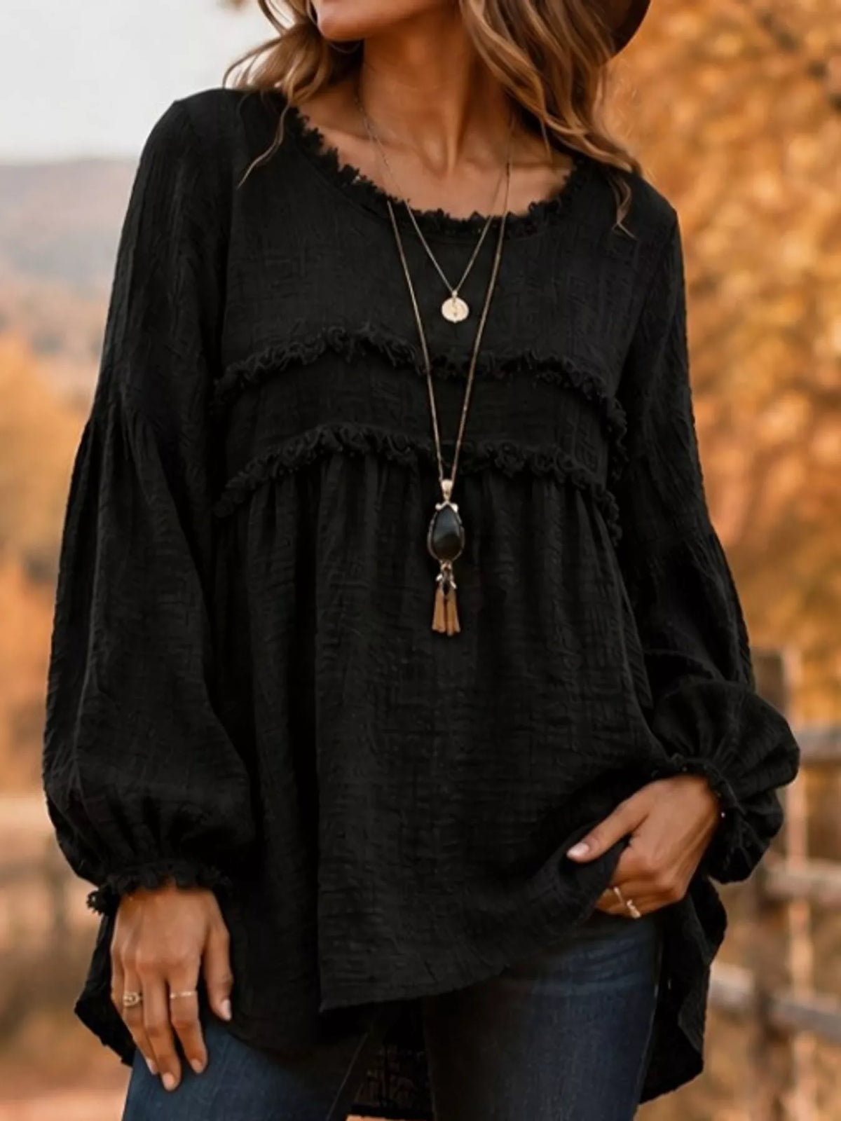 Black frayed trim peplum blouse with tiered ruffle detail and long puff sleeves