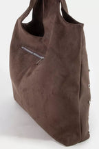 Suede shoulder tote in dark brown with adjustable strap tab and metal accent hardware
