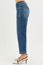 Women’s dark wash jeans side view with five-pocket styling and ankle hem