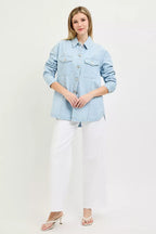 Light blue denim shacket with button front and flap chest pockets over white pants