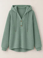 Waffle-knit button hoodie in sage green, front view with hood and drawstring cords.