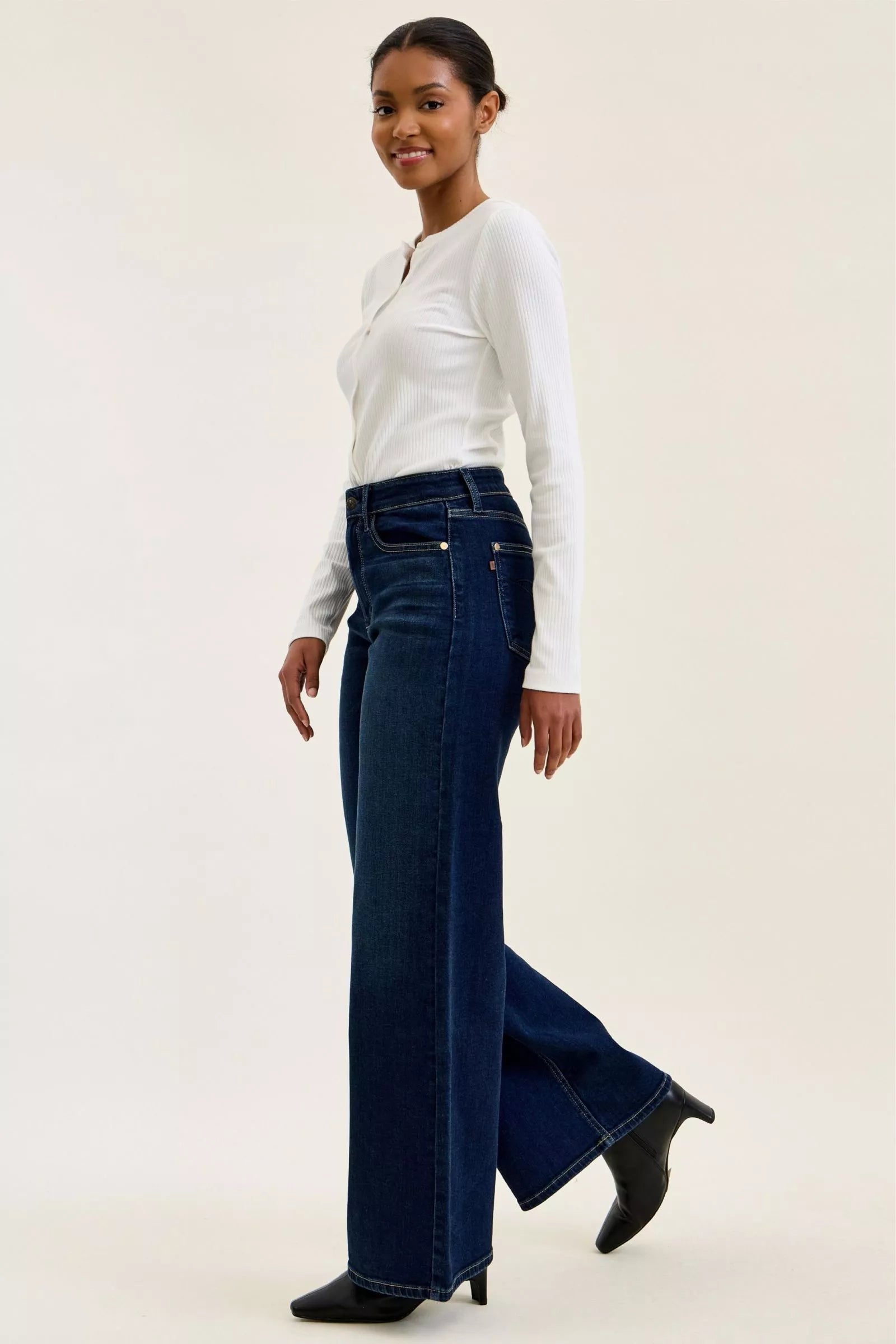 Dark wash wide-leg jeans side view with long flared leg and button closure