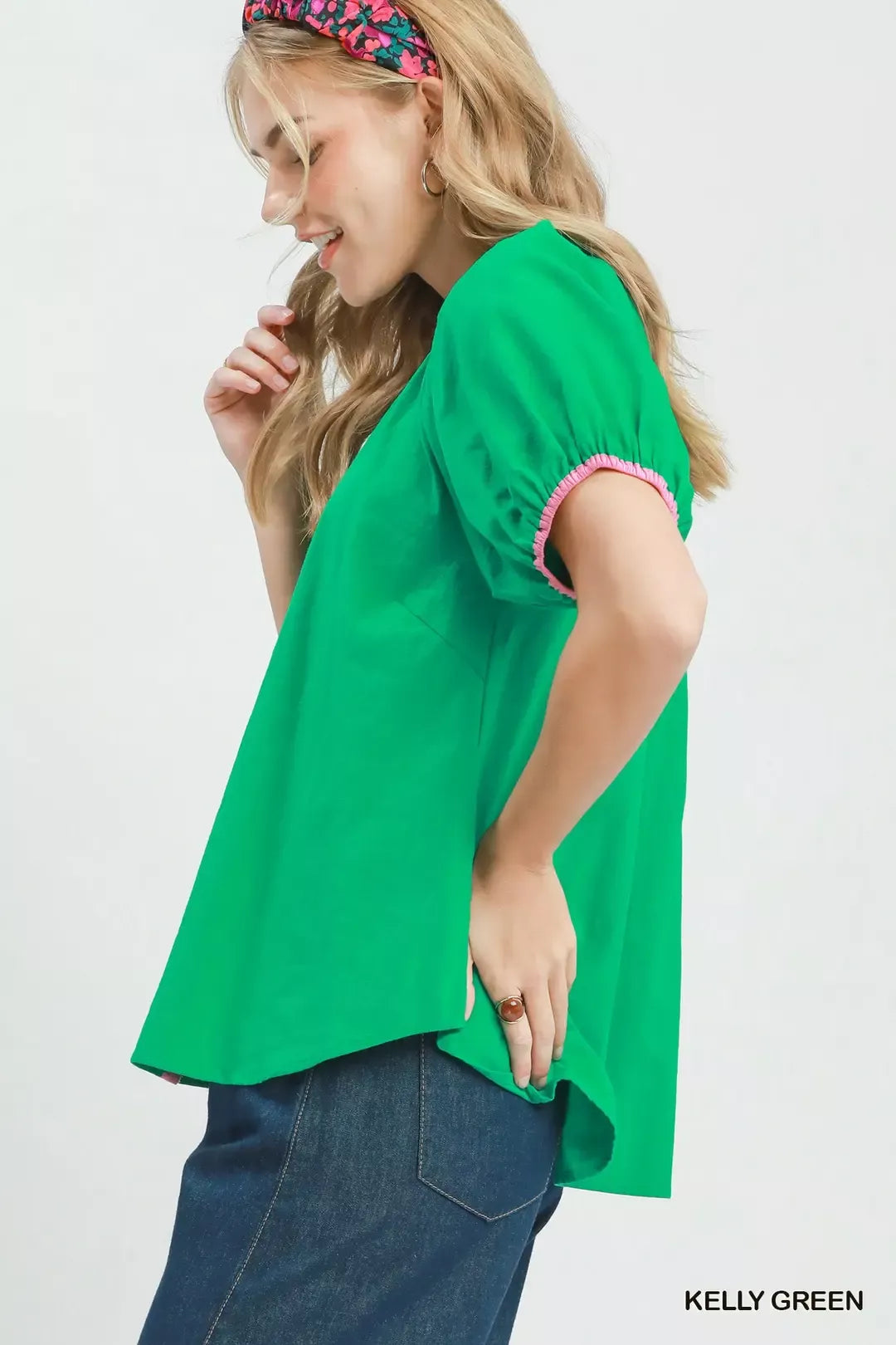Green blouse with pink-trimmed puff sleeves and button front, side view