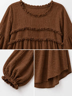 Brown blouse close-up: frayed tiered ruffle trim and elastic puff sleeves