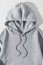 Close-up of heather gray drawstring hoodie hood with wavy cord and kangaroo pocket.