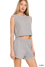 Grey ribbed knit sweater vest with stitch-detail neckline, worn with matching shorts