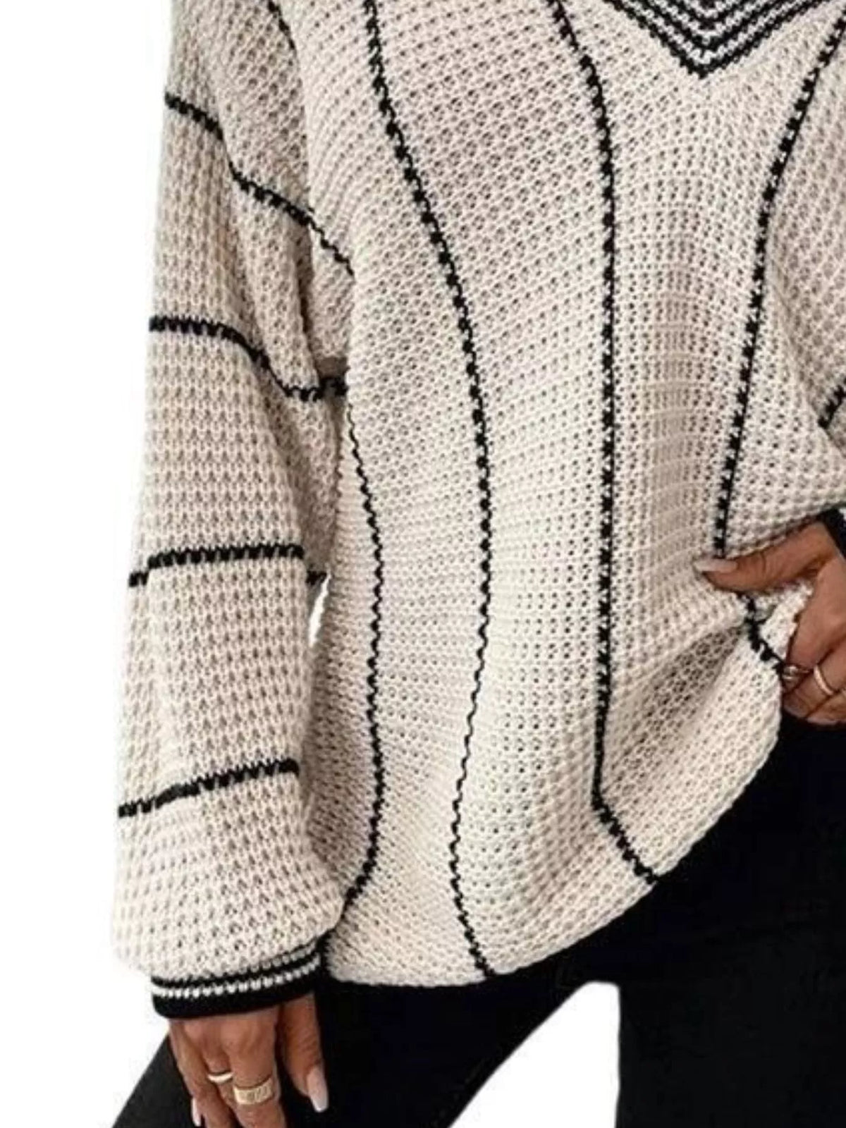Cream textured knit sweater with black vertical stripe design and ribbed cuffs.