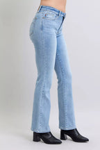 Judy Blue mid-rise thermal bootcut jeans in light wash, side view with flared hem