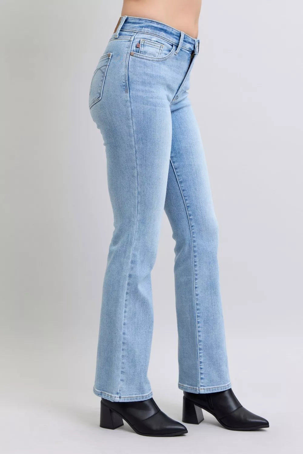 Judy Blue mid-rise thermal bootcut jeans in light wash, side view with flared hem