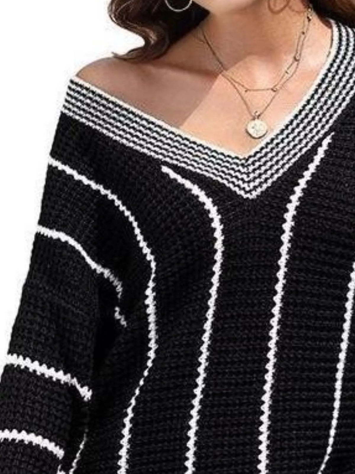 Black V-neck textured knit sweater with white vertical stripes and wide V neckline trim