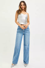 Women's medium-wash straight jeans on model, relaxed fit, wide leg opening