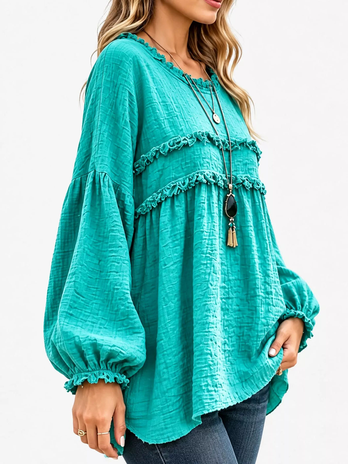 Teal frayed trim peplum blouse, angled side view, with puff sleeves and ruffle tiers