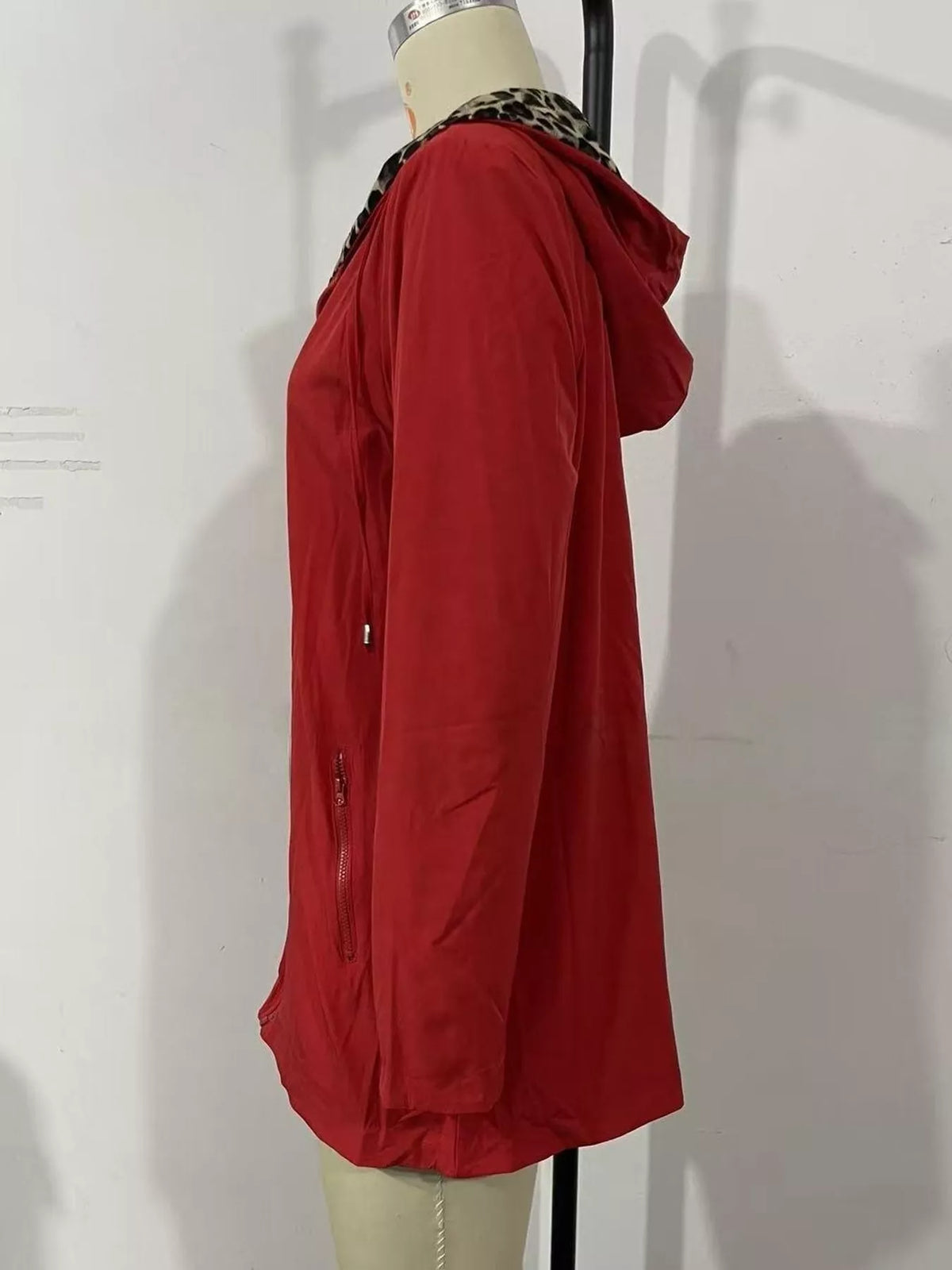 Red hooded drawstring waist jacket with zip front, side view on mannequin