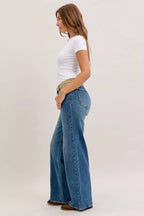 Women’s mid-rise straight jeans in blue denim with tan corduroy waistband, angled side view